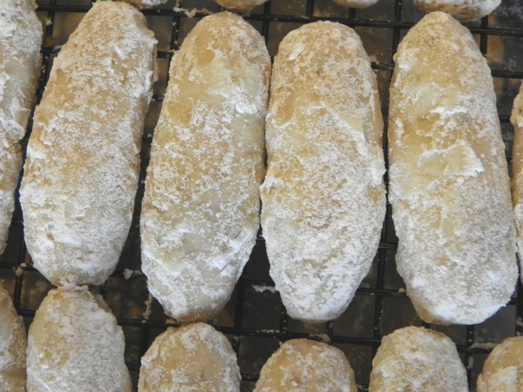 several pieces of bread sitting on top of a cooling rack covered in powdered sugar