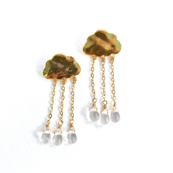 April showers bring May flowers, but these raindrops bring style, whimsy, and joy to any occasion. Tiny glass droplets hand-wired to 14 karat gold filled chains fall gracefully from etched golden clouds (in gold over brass) and between golden glimmer and a charming shimmy, this weather is so much fun to wear in rain or shine. Each measures 1.5" length with stainless steel posts. Golden Clouds, April Showers Bring May Flowers, Keep Your Chin Up, April Showers, May Flowers, Fun Events, Gold Filled Chain, Gold Filled, Brass