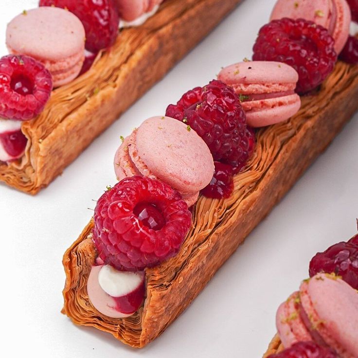 raspberries and other desserts are arranged on bread