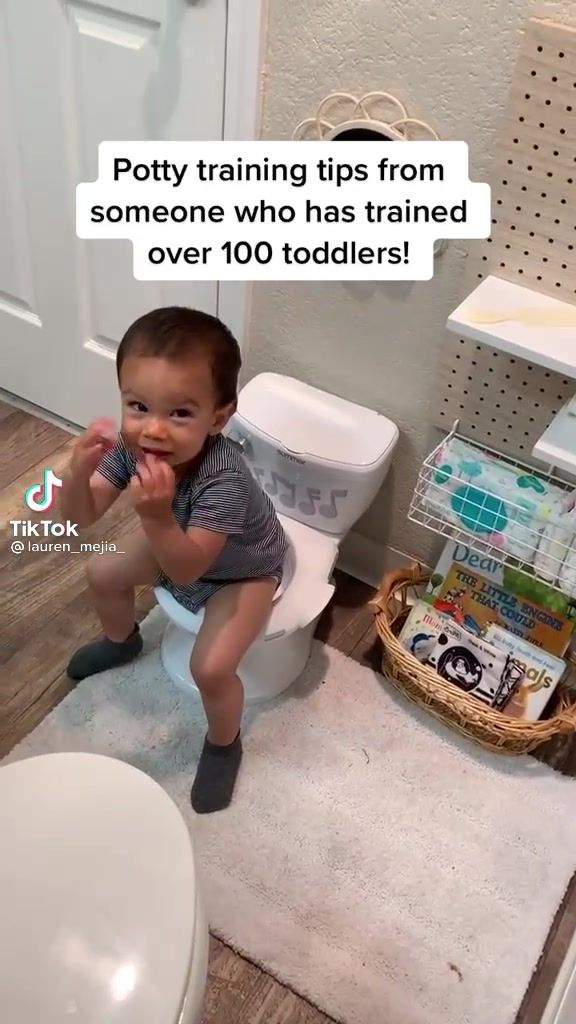 a baby sitting on top of a toilet in a bathroom