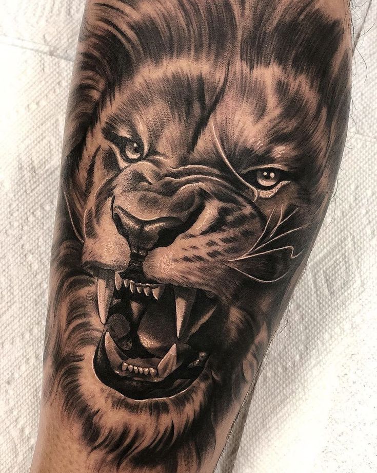 a man's arm with a tattoo of a lion on it