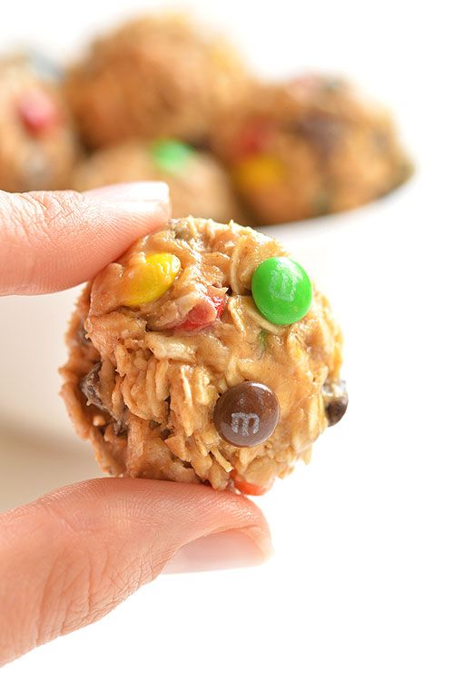 a hand holding an oatmeal cookie with m & m candies on it