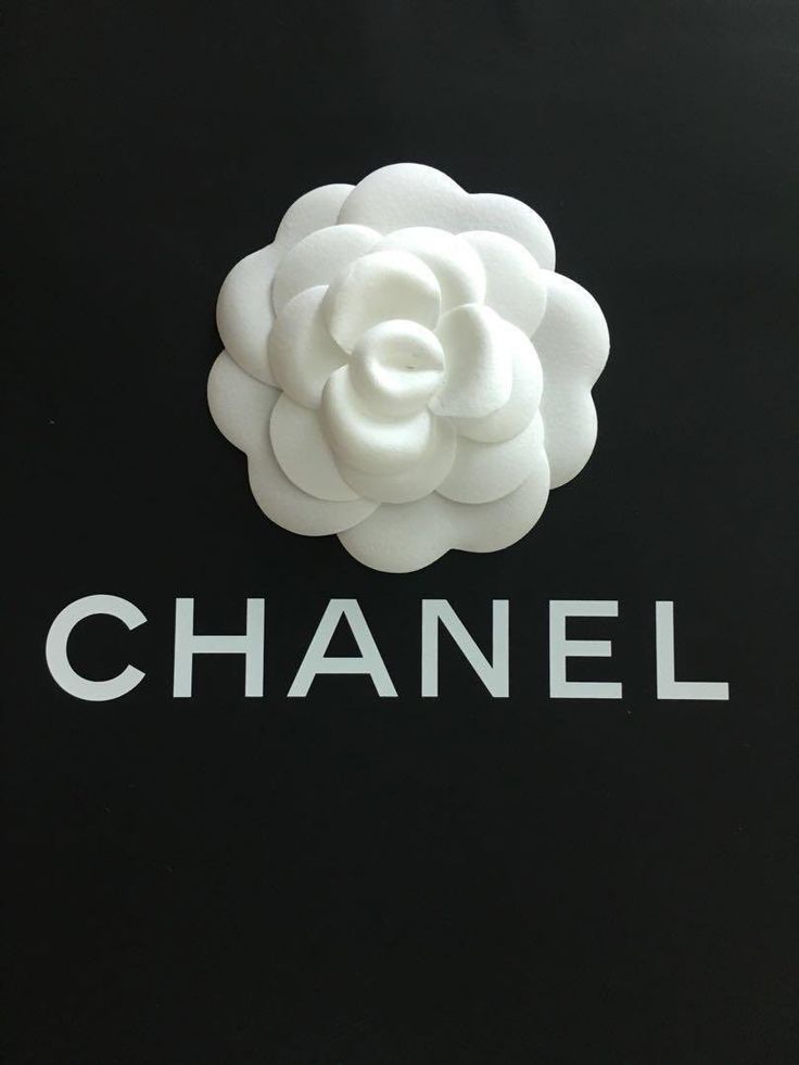 the chanel logo is shown on a black background with white flowers and letters below it