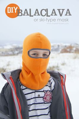 a person wearing a yellow mask standing in the snow