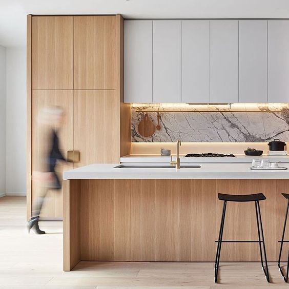 a kitchen with two stools next to an island and counter top that has marble on it