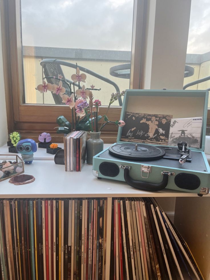 an old record player sitting on top of a table next to a bunch of records