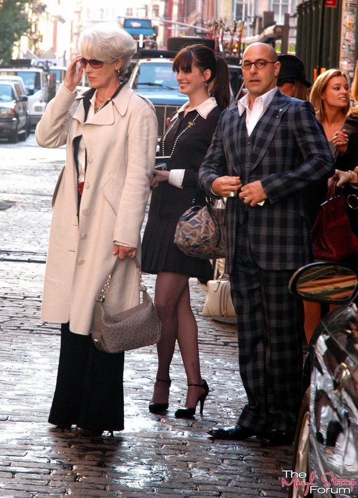 people walking down the street on a rainy day with one woman talking on her cell phone