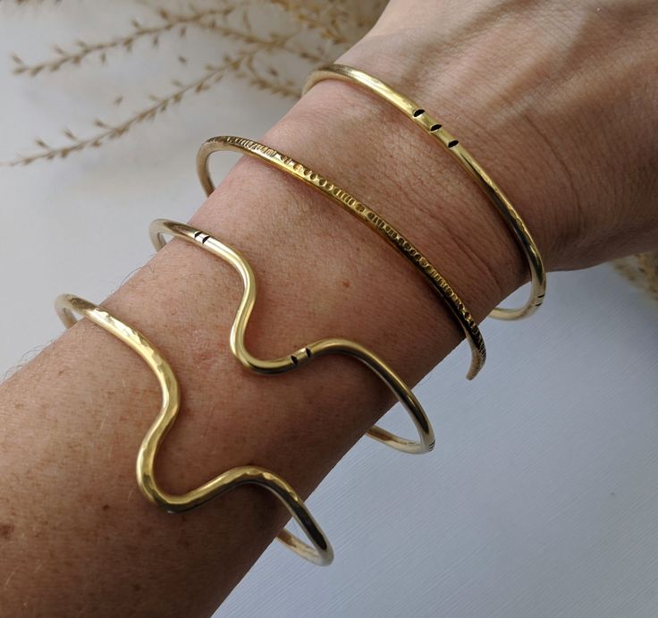 "Another versatile classic, handcrafted from raw brass.  Wear one alone for a minimalist touch, or stack them up for a bolder bohemian look. Choose from 4 styles of cuff, or make it a set of 4 Find your perfect fit: All cuffs are adjustable, but ordering the correct size will ensure your most comfortable fit. Measure the circumference of your wrist by wrapping a flexible tape measure around the wrist just below the wrist bone, making note of where the tape overlaps.  Use the chart below to determine your size: S - 5 - 6\" M - 6 - 6.5\" L - 6.5 - 7\" XL - 7 - 8\" For a looser bangle-style bracelet consider sizing up one or two sizes. Please note that because each piece is handmade to order, yours may differ slightly from the ones pictured above but will of course stay true to them in essenc Modern Brass Bangle For Everyday Wear, Everyday Brass Bangle Cuff Bracelet, Minimalist Handmade Brass Bangle, Handmade Minimalist Brass Bangle, Handmade Gold Cuff Bracelet For Everyday, Everyday Handmade Gold Cuff Bracelet, Gold Handmade Minimalist Cuff Bracelet, Minimalist Everyday Brass Bangle, Everyday Minimalist Brass Bangle