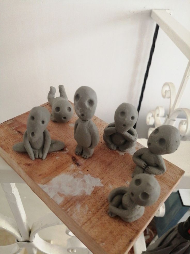 several clay elephants sitting on a wooden table