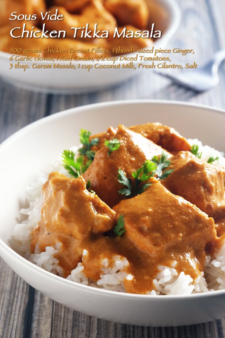 a white bowl filled with chicken tikka masala on top of rice and garnished with parsley