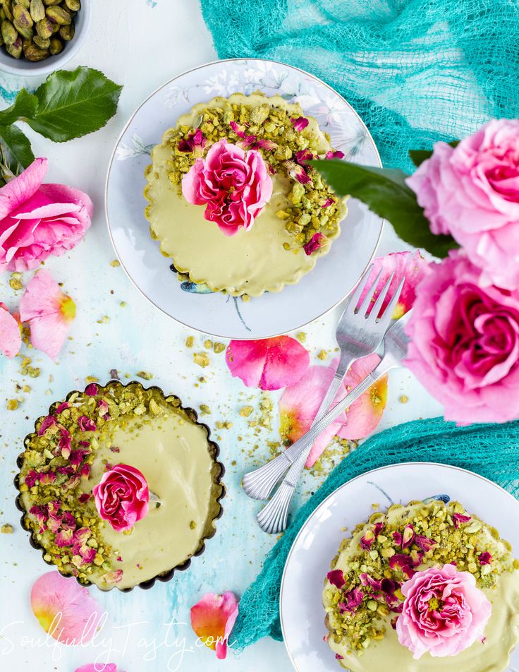 two small cakes with flowers on them sitting next to each other and one has a fork in it