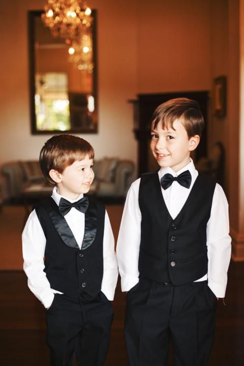 two young boys dressed in black and white tuxedos