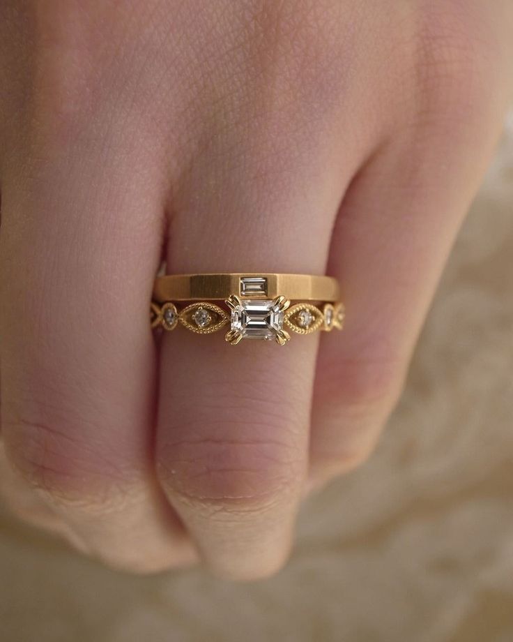 a woman's hand with a gold ring and diamond band on her left wrist