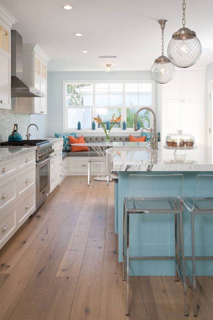 a kitchen with white cabinets and an island in front of the stove top oven is shown