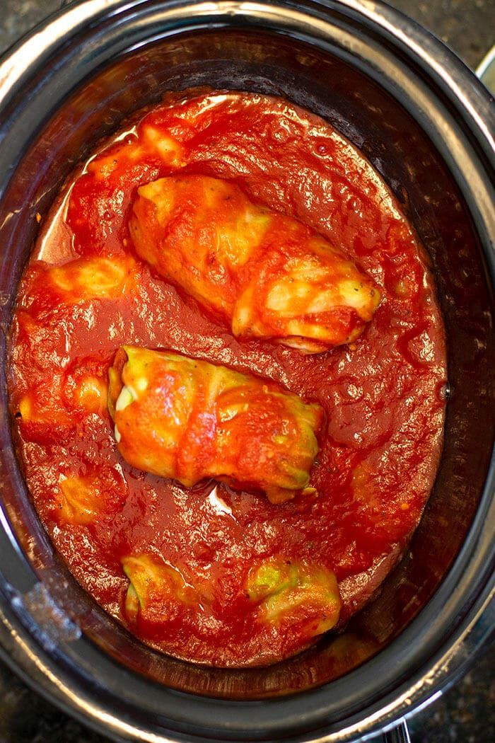 two pieces of meat covered in marinara sauce inside an instant pressure cooker pot