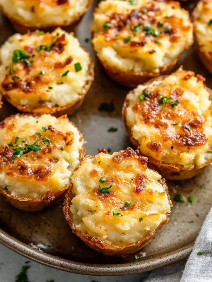 baked potatoes with parmesan cheese and herbs on a plate, ready to be eaten