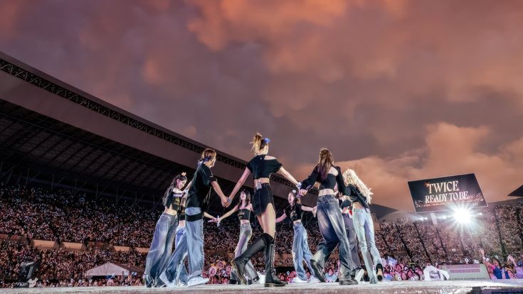 a group of women standing on top of a stage in front of a large crowd