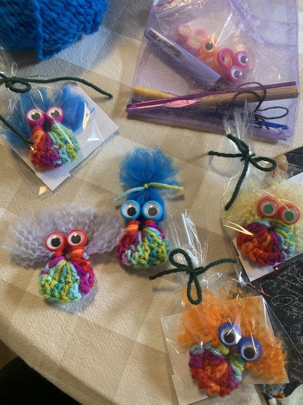 some little owls made out of yarn sitting on a table