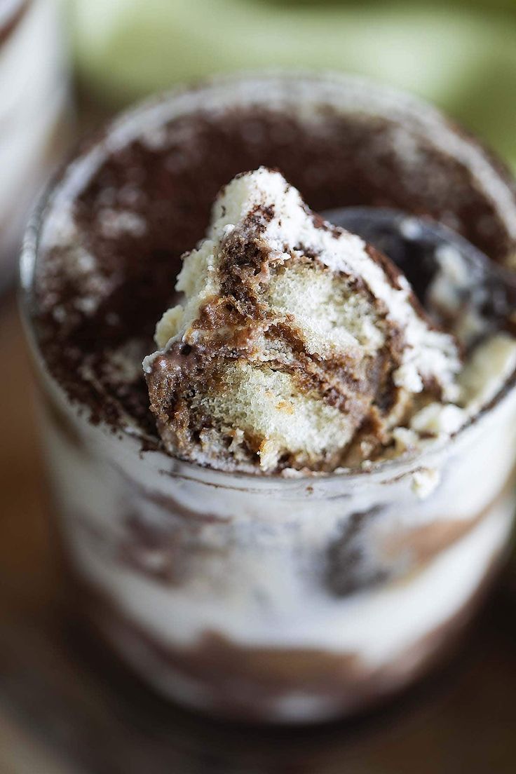 an ice cream dessert in a glass with chocolate sauce and powdered sugar on top