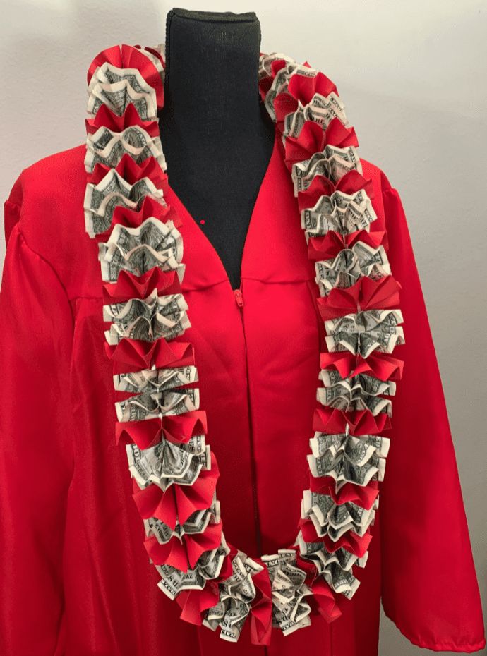 a red graduation gown with dollar bills on the front and neck, along with a black mannequin