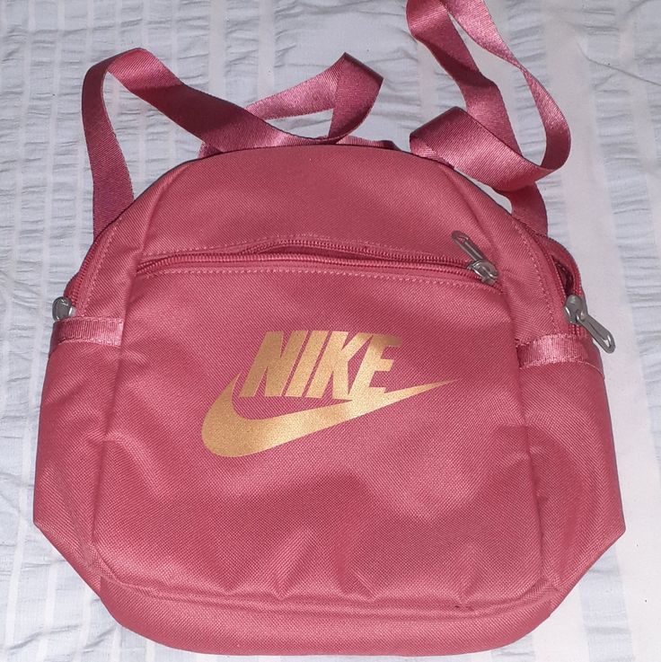 Nike Pink Backpack W/ Gold Nike Emblem Small Bag But Holds Alot. Great For Bag To Lug Stuff Around Like Beach, Amusement Park, Or Just Everyday Nike Bags With Zipper Closure For Back To School, Nike Shoulder School Bag, Nike Shoulder Bag For School, Nike School Bag With Adjustable Strap, Nike School Bags With Zipper Closure, Nike Pink Bag For Daily Use, Pink Nike Backpack For School, Nike Pink Backpack For School, Nike Pink Backpack For Travel