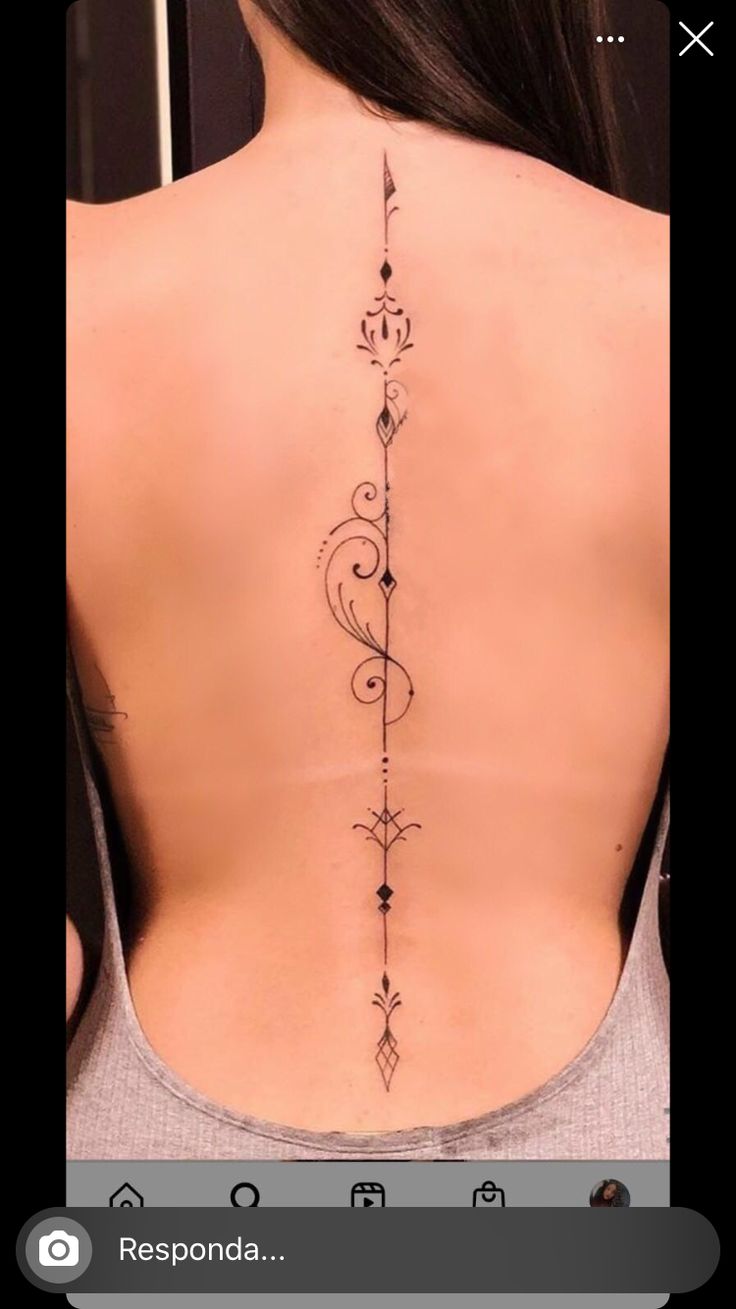 the back of a woman's neck with an intricate tattoo design on her left side