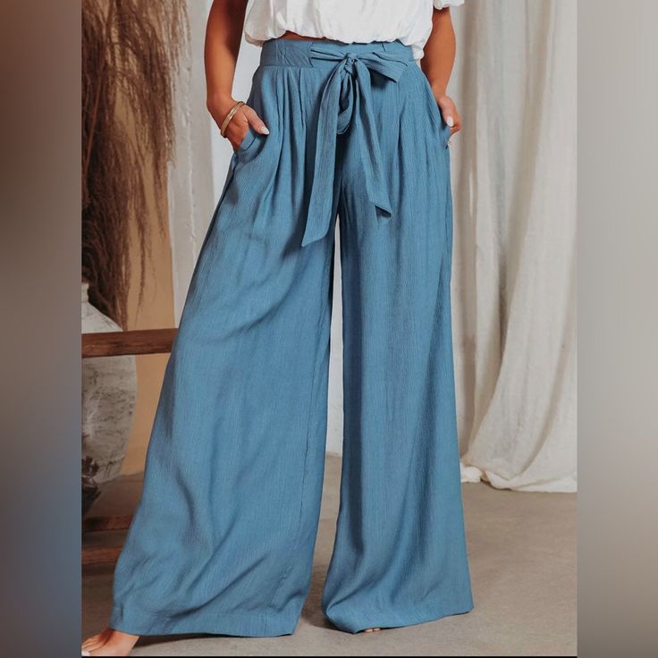 Introducing Our Stylish And Versatile Blue Wide Leg Pants For Women. Crafted With Utmost Care And Attention To Detail, These Pants Are Designed To Provide Both Comfort And Fashion-Forward Style. Made From High-Quality Fabric, They Offer A Flattering Fit And A Relaxed Silhouette That Effortlessly Complements Any Body Type. Whether You're Dressing Up For A Special Occasion Or Simply Want To Elevate Your Everyday Look, 100% Polyster Drawstring Closure Hand Wash Or Machine Wash Material: Linen And C Non-stretch Blue Bottoms For Summer, Blue Non-stretch Vacation Pants, Blue Cotton Tie Waist Bottoms, Blue Cotton Bottoms With Tie Waist, Blue Tie Waist Bottoms For Spring, Light Blue Wide-leg Pants With Pockets, Blue Cotton Solid Color Pants, Light Blue Wide-leg Pants, Blue Bottoms With Tie Waist For Spring