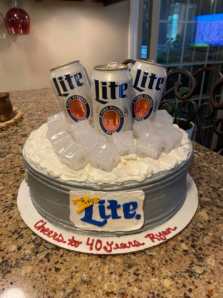 a cake that is sitting on top of a countertop with beer cans and ice cubes in it