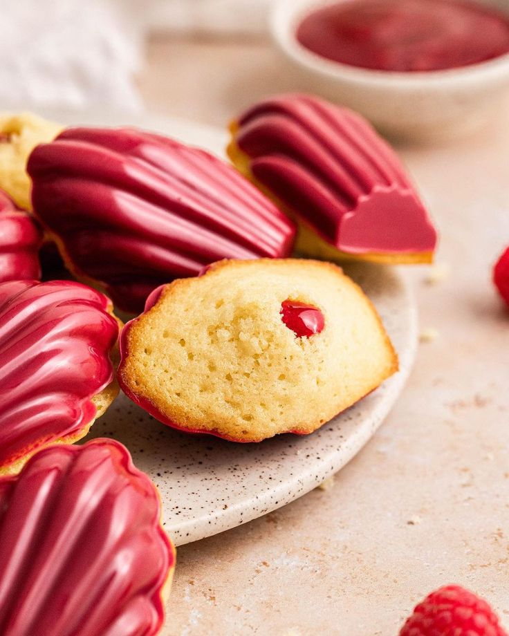 raspberry shortbreads on a plate next to some raspberries