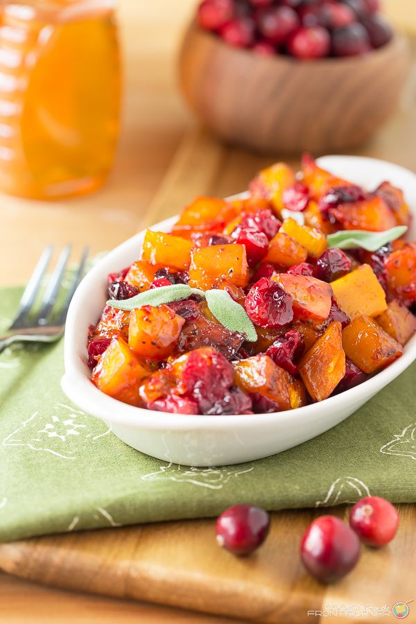 a white bowl filled with cranberry and orange salad on top of a green napkin