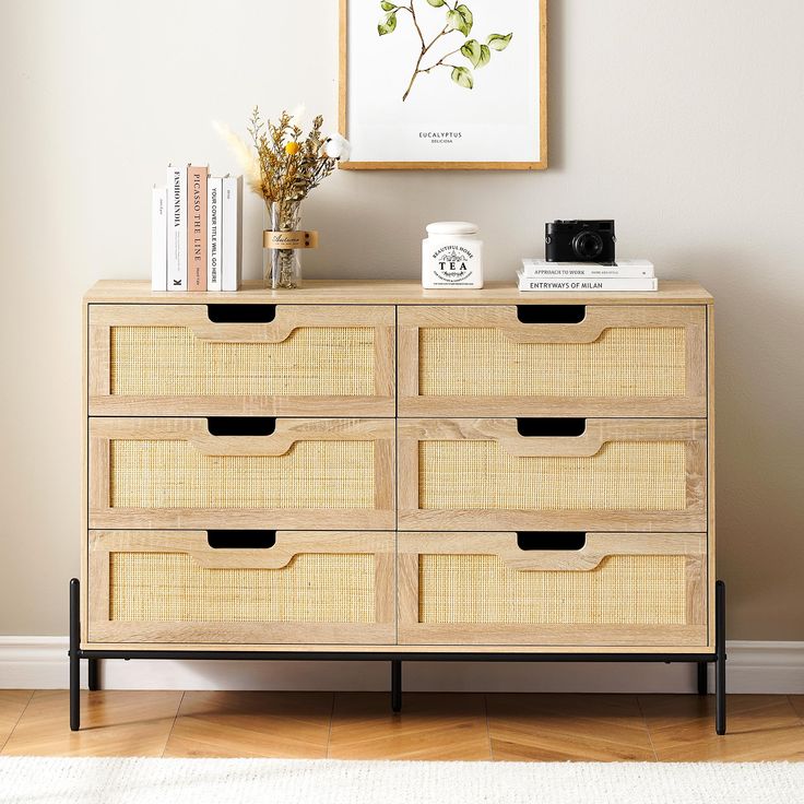 a wooden dresser with baskets and books on top in a room next to a wall