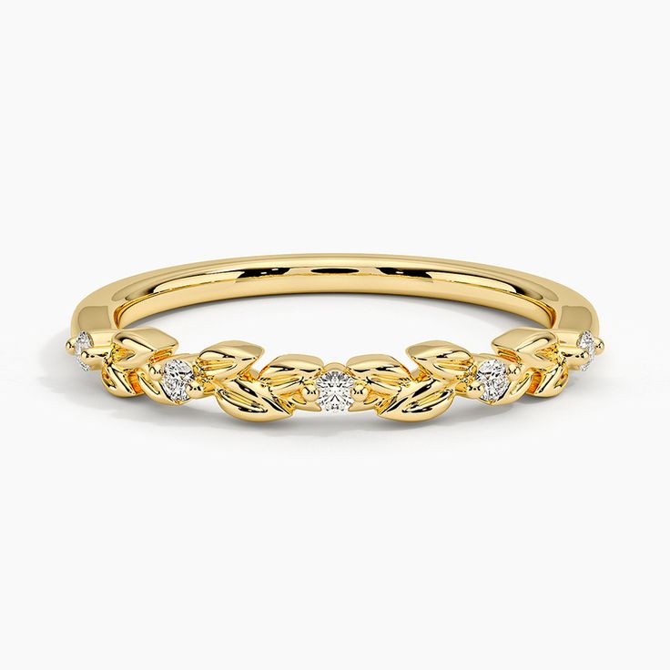 a yellow gold wedding band with three small diamonds on the top and bottom, set against a white background