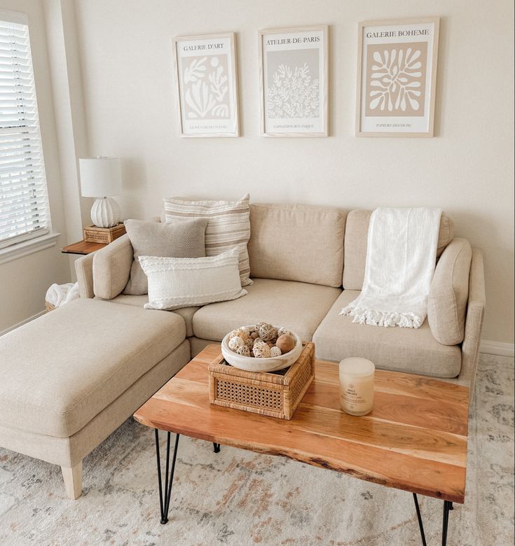 a living room with a couch, coffee table and two pictures on the wall above it