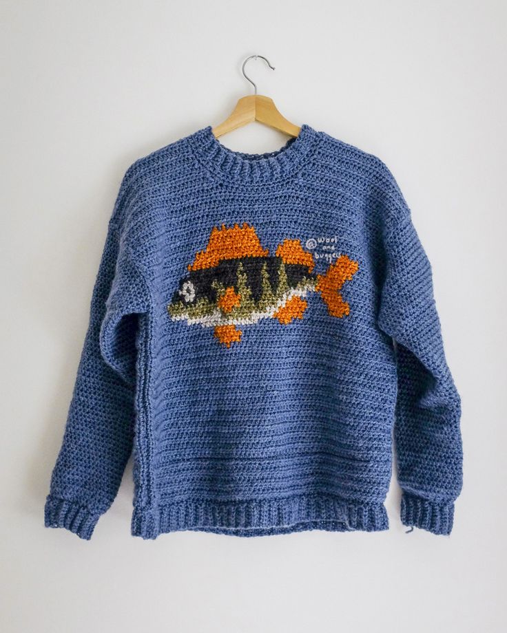 a blue sweater with an orange fish on it