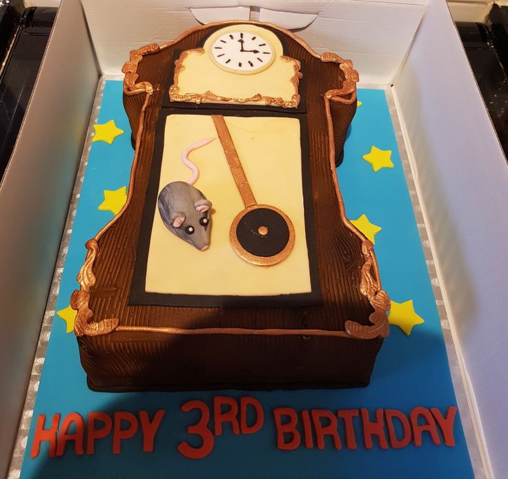 a birthday cake in the shape of a clock with a rat on it's face