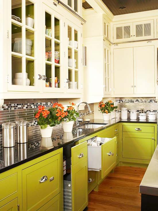 a kitchen with yellow cabinets and black counter tops