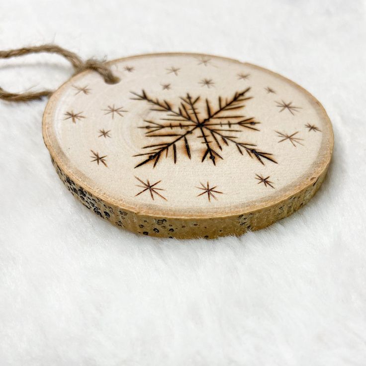 a wooden ornament with a snowflake design on it sitting on a white surface