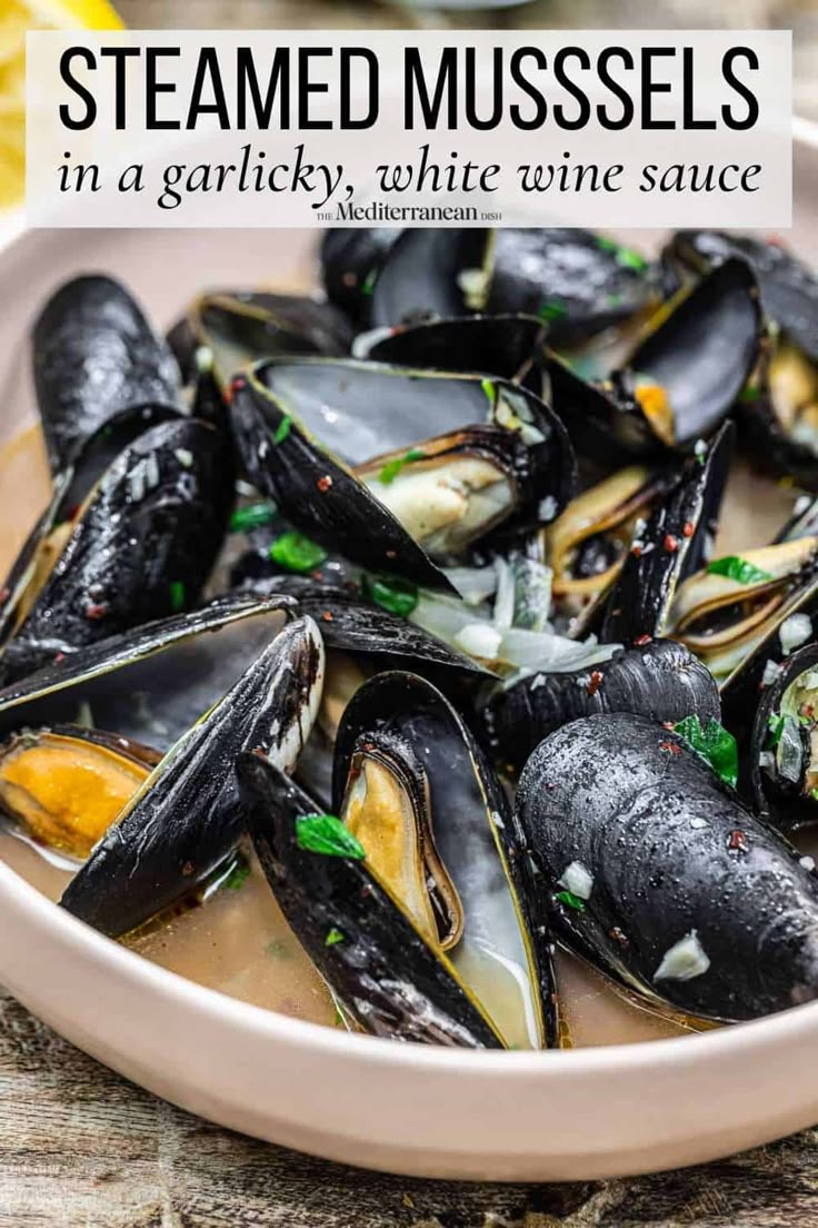 steamed mussels in a bowl with lemon wedges and parsley on the side