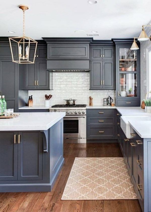 a kitchen with gray cabinets and white counter tops