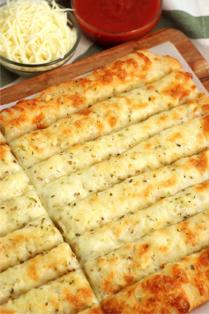 homemade cheesy breadsticks with cheese on top and in the background, there is