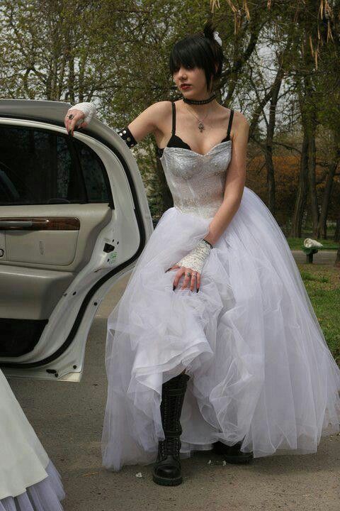 a woman in a white dress sitting next to a car