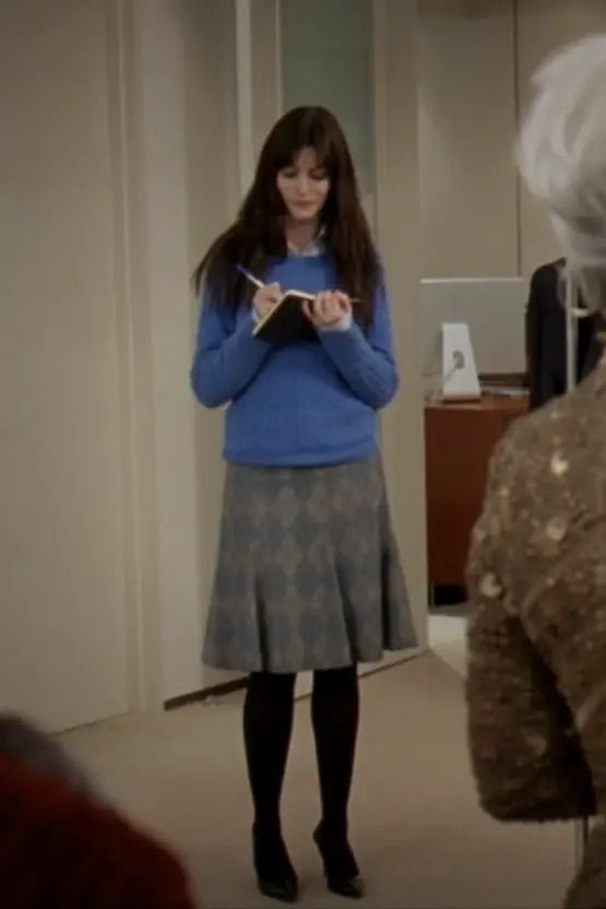 a woman standing in front of a mirror looking at her cell phone