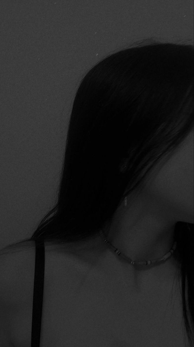 black and white photograph of a woman with her back to the camera, wearing a choker