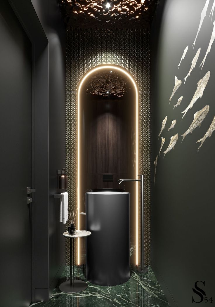 the bathroom is decorated in black and gold with fish on the wall, along with a round mirror