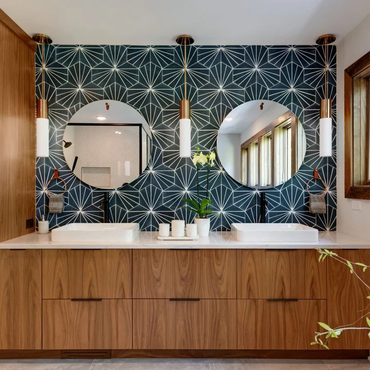 a bathroom with two sinks and mirrors on the wall next to each other in front of a large mirror