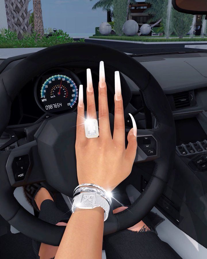 a woman's hand on the steering wheel of a car, with white nails