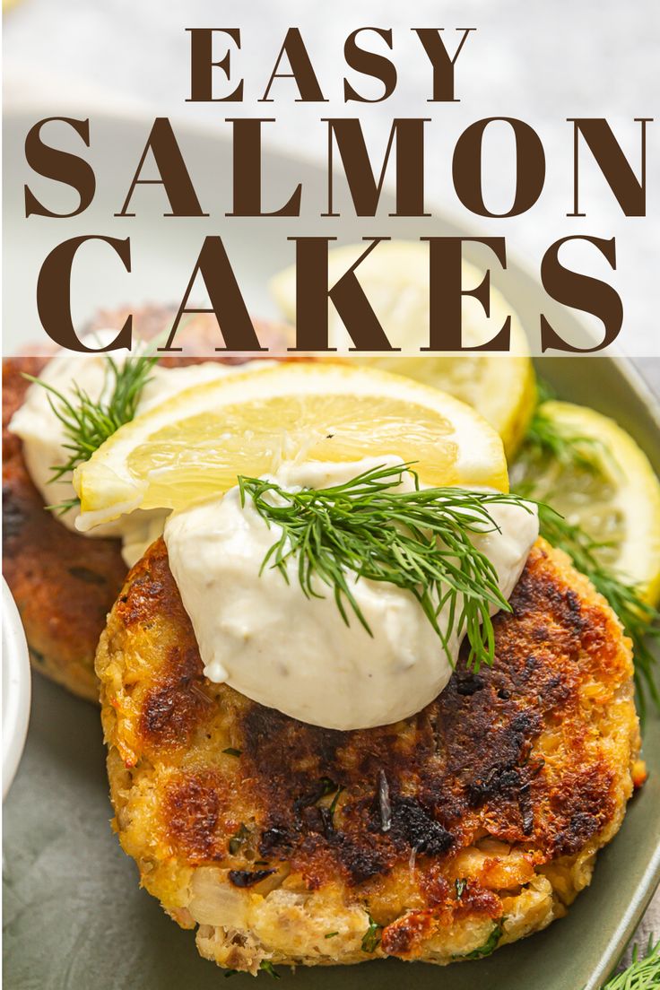 salmon cakes on a plate with lemon wedges and dill