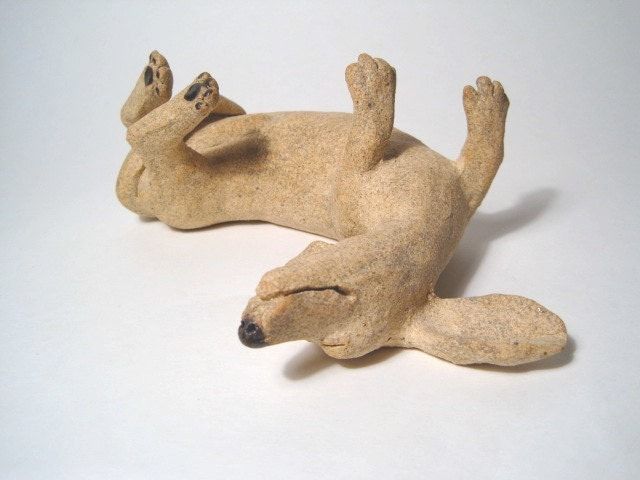 a small ceramic animal laying on its back