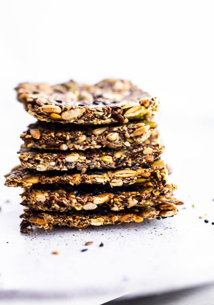 homemade multi seed crackers stacked on top of each other with the title text above it