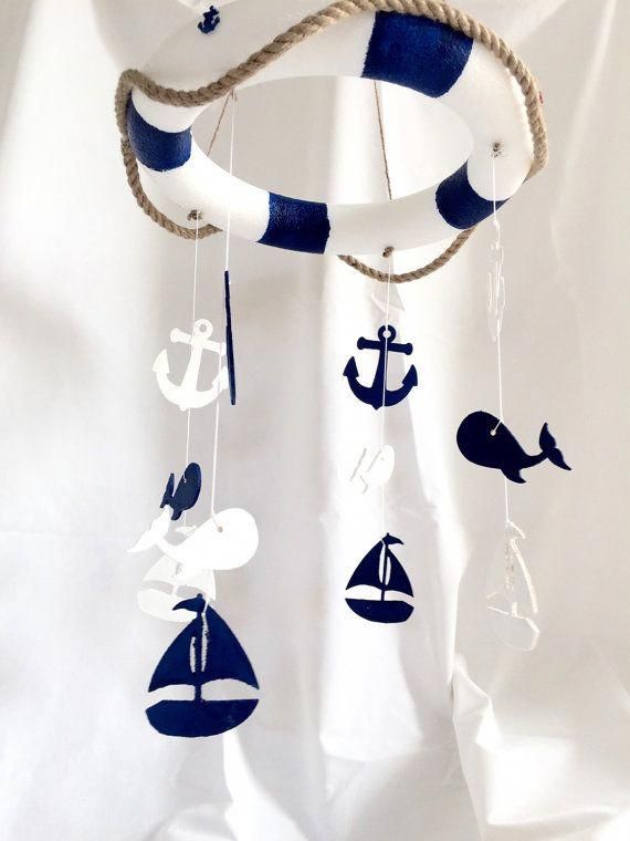 a blue and white mobile with an anchor, whale, sailboat, and boat on it